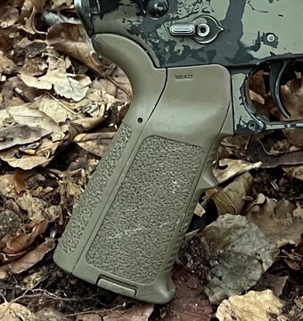 A Magpul MIAD pistol grip on an AR-15 lower receiver: an ergonomic, textured polymer handle. Source Wikimedia Commons (NobuttoO, CC0).